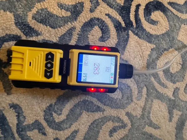 Hydrogen detector reading 296 ppm over the leak position on a living room floor